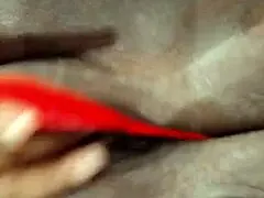 An ebony woman is enjoying some personal time with toys in lingerie