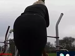 Mature milf struts big ass in tight leggings while walking through park.