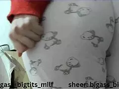 mature woman in pajamas masturbates with vibrator, showing wet cameltoe and big natural tits