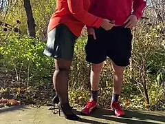 Mother-in-law assists with outdoor urination in public, wearing pantyhose and heels.