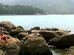 A mature man fucks an exotic babe on seaside stones
