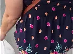 Following this mature woman in her skirt and thong on the street