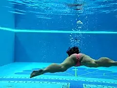 In the pool, a Hungarian woman plays naked sazan cheharda, swimming and teasing underwater with playful moves.