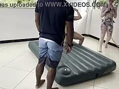 Two hotties inflate inflatable mattress with street man's help.