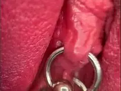 close up on shaved pussy lips and pierced clit as she pisses outdoors