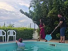 Wife takes husband's friends in kitchen while he cleans pool outside