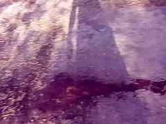 A milf pees outdoors behind garages.